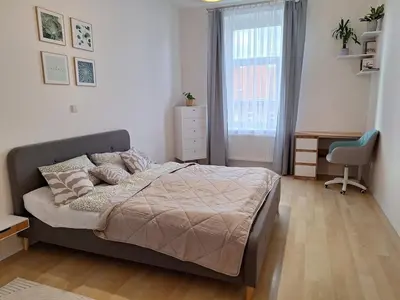 a bedroom with a bed and a desk and a window at Cozy and newly equipped apartment in Prague