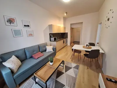 a living room with a blue couch and a table at Cozy and newly equipped apartment in Prague