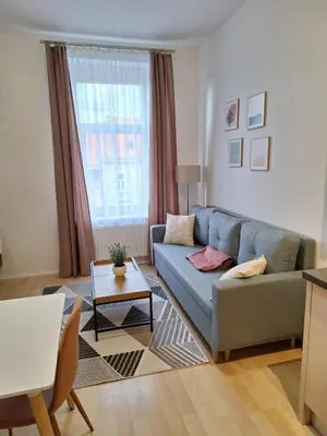 a living room with a couch and a table at Cozy and newly equipped apartment in Prague
