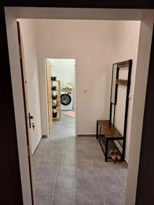 a hallway with a room with a mirror and a table at Cozy and newly equipped apartment in Prague