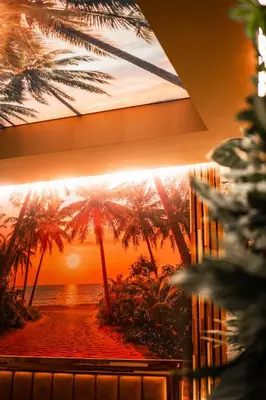 a painting of a beach with palm trees on a wall at Coco Suite Private Spa and Jacuzzi Prague Center in Prague