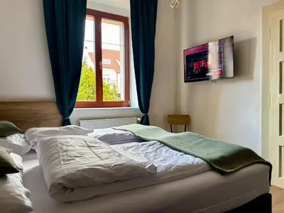 an unmade bed in a bedroom with a window at Urban Studio - Tram Stop at Your Door, Metro 5-min Walk in Prague