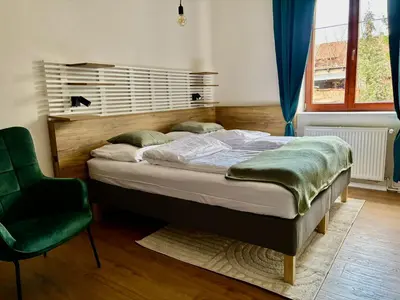 a bedroom with a bed and a green chair at Urban Studio - Tram Stop at Your Door, Metro 5-min Walk in Prague