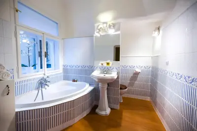 a white bathroom with a tub and a sink at Apartments U Krále Brabantského in Prague