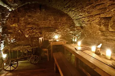 a room with two tables and candles in a cave at Apartments U Krále Brabantského in Prague