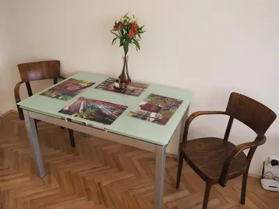 a green table with a vase of flowers and two chairs at Stylish studio near Jezerka park in Prague