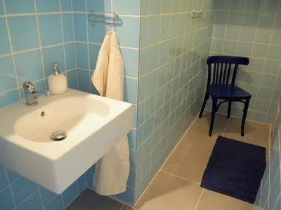 a bathroom with a sink and a black chair at Stylish studio near Jezerka park in Prague