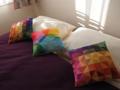 a bed with two colorful pillows on it at Stylish studio near Jezerka park in Prague