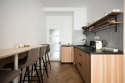 a kitchen with a counter and a bar with stools at Place of Grace - Anděl 1 min to subway in Prague