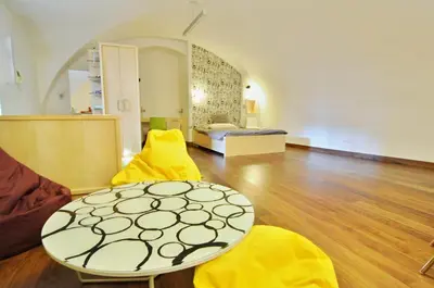 a living room with a table and yellow chairs at Apartment Trziste in Prague