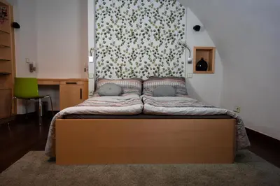 a small bed in a room with a wall at Apartment Trziste in Prague