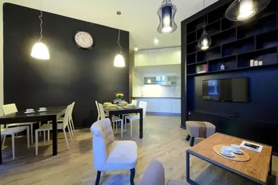 a dining room with a table and a clock on the wall at DeLuxe Apartment in Prague