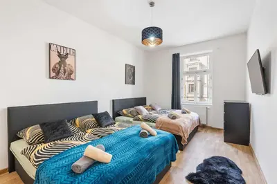 a bedroom with two beds and a couch at Big Boss Apartment in Prague