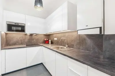 a kitchen with white cabinets and a sink at Big Boss Apartment in Prague