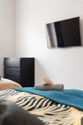 a bedroom with a bed with a tv on the wall at Big Boss Apartment in Prague