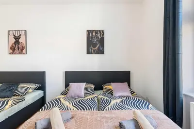 a bedroom with two beds and two pictures on the wall at Big Boss Apartment in Prague