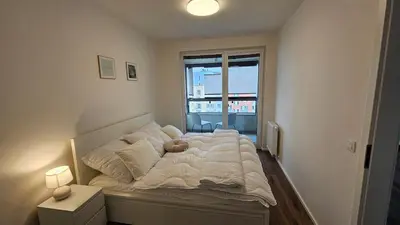 a bedroom with a large bed with a window at Klamovka stylish Apartment by Rentez in Prague