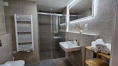 a bathroom with a sink and a toilet and a mirror at Klamovka stylish Apartment by Rentez in Prague