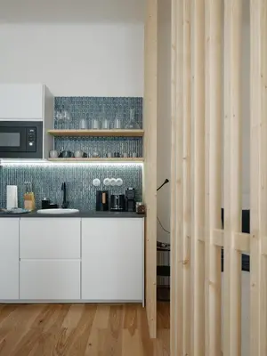 a wooden table with plates and a vase of flowers at Stylish Architect Apartment Prague 1 Best Location in Prague