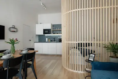 a bedroom with a bed with white sheets and blue pillows at Stylish Architect Apartment Prague 1 Best Location in Prague