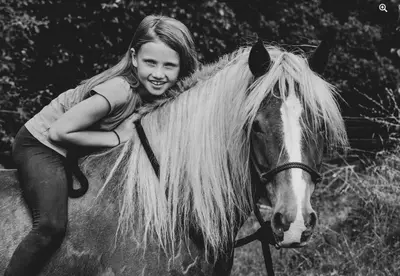 a young girl riding on the back of a horse at Glamping nad Meandry v jurtě in Chyňava