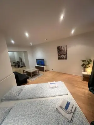 a bedroom with two beds and a living room at Kroftova12 in Prague