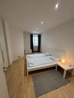 a bedroom with two beds and a table with a lamp at Kroftova12 in Prague