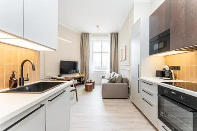 a small bedroom with a bed with a window at Rentero Modern Spacious Apartment in Central Prague in Prague