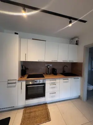 a kitchen with white cabinets and a sink and a stove at Green Resort Slapy