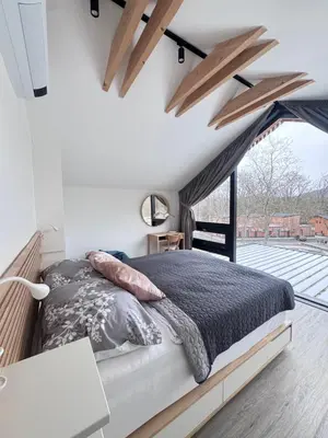 a bedroom with a bed and a large window at Green Resort Slapy