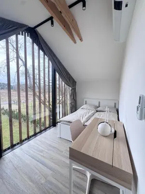 a bedroom with a table and a bed and a large window at Green Resort Slapy
