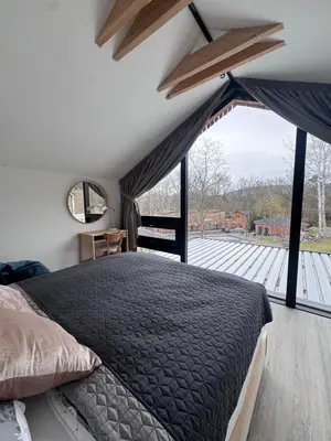 a bedroom with a bed and a large window at Green Resort Slapy