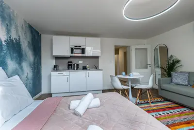 a bedroom with a bed and a table and a kitchen at Cozy Forest Studio - Calm - Central - Stylish in Prague