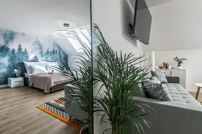 two pictures of a living room with two plants at Cozy Forest Studio - Calm - Central - Stylish in Prague