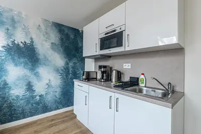 a kitchen with white cabinets and a sink at Cozy Forest Studio - Calm - Central - Stylish in Prague