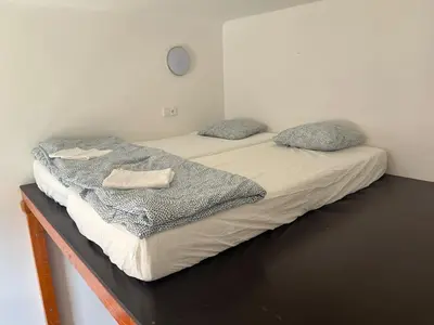 two twin beds in a room with a clock on the wall at Central cozy rooms Soukenická S36 in Prague