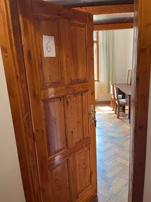 a wooden door in a room with a table at Central cozy rooms Soukenická S36 in Prague
