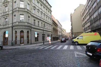 a city street with cars and a yellow van at Central cozy rooms Soukenická S36 in Prague