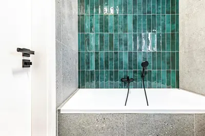a bathroom with a shower with green tile at Under the Airship, Prague in Prague