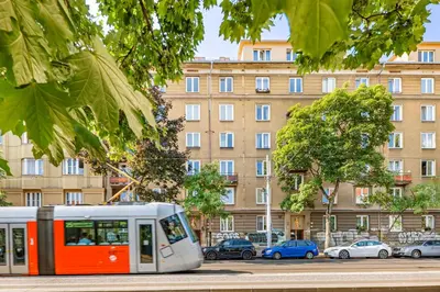 a bus driving down a street in front of a building at Under the Airship, Prague in Prague