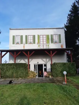 a white house with a dog sitting in front of it at Penzion Mirja