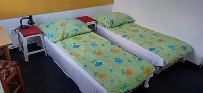 two beds sitting next to each other in a room at Penzion Mirja