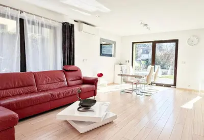 a living room with a red couch and a table at Modern house with pool, 20 minutes from the center of Prague in Prague