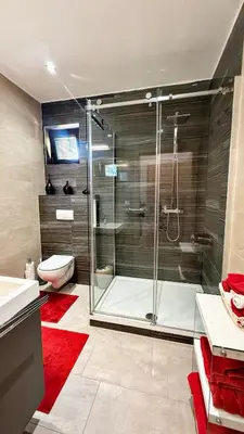 a bathroom with a glass shower and a toilet at Modern house with pool, 20 minutes from the center of Prague in Prague