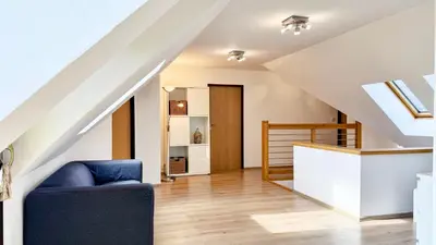 a living room with a blue couch and a staircase at Modern house with pool, 20 minutes from the center of Prague in Prague