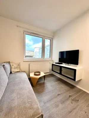 a living room with a couch and a flat screen tv at Modern Studio with Walk to O2 Arena and Metro in Prague