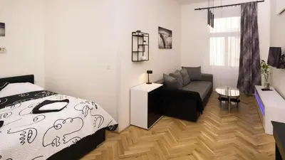 a bedroom with a bed and a chair and a couch at Black & White Apartment Prague by Wenceslas Square and Muzeum in Prague