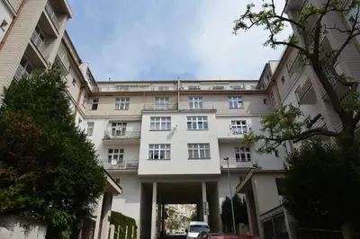 a large white building with a parking garage at Garden Apartment in Prague