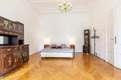 a bedroom with a bed and a clock on the wall at Royal Apartment by Charles Bridge view of Saint Nicholas Church in Prague