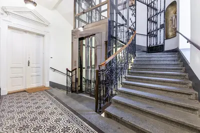 a staircase with metal railings and a white door at Royal Apartment by Charles Bridge view of Saint Nicholas Church in Prague